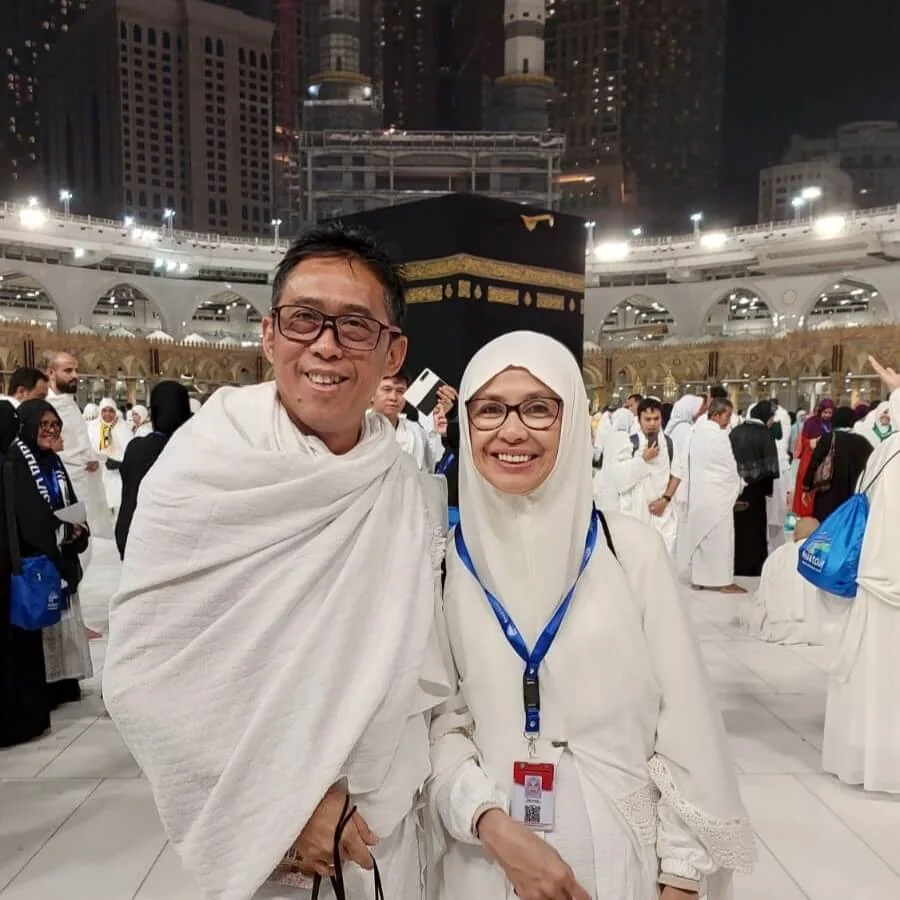 Pasangan menunaikan Umrah dengan latar belakang Kaabah